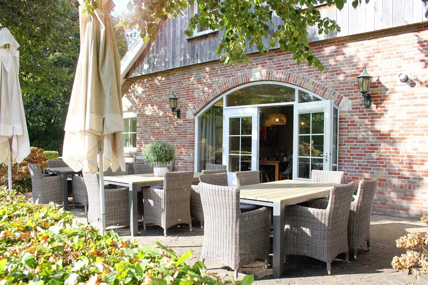 Terrasse vom Haus mit Abgrenzung durch eine Hecke. 